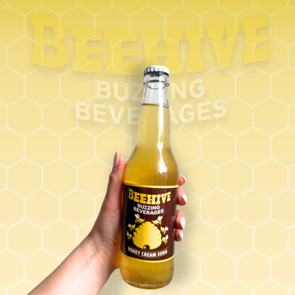 Hand holding a bottle of Avery’s Honey Infused Cream Soda in glass bottle on yellow gradient background