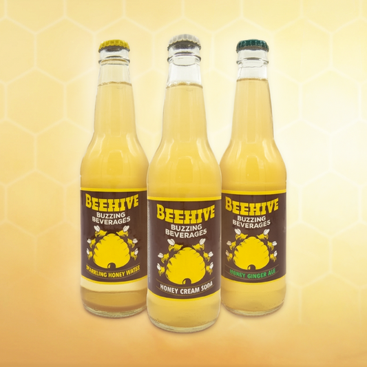 Avery’s Honey Infused Soda Variety 12-Pack with sparkling honey water, honey cream soda and honey ginger-ale flavors in glass bottles on yellow gradient background