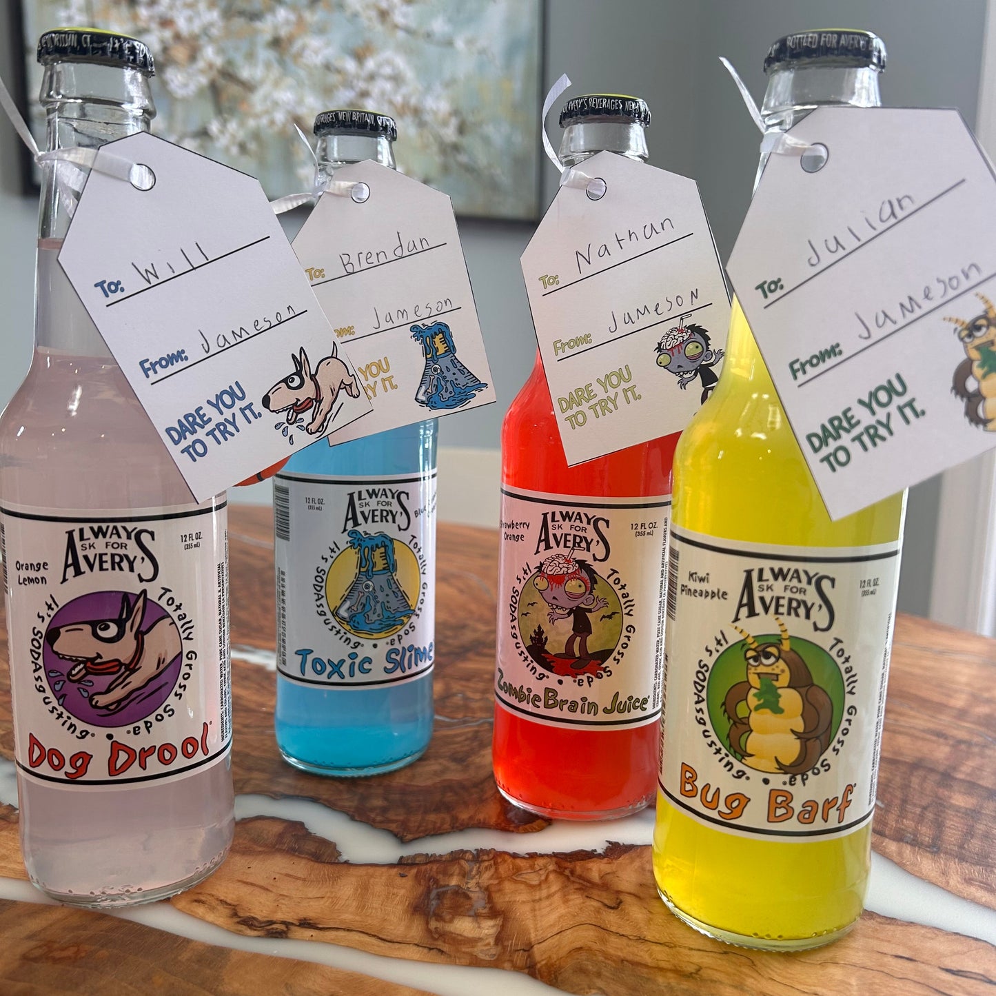 Avery's Totally Gross gifting tags hanging from colorful glass bottles with to and from names handwritten on the tags